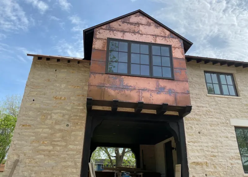Copper metal panel facade on a stone building for Roof Repair in Lantana